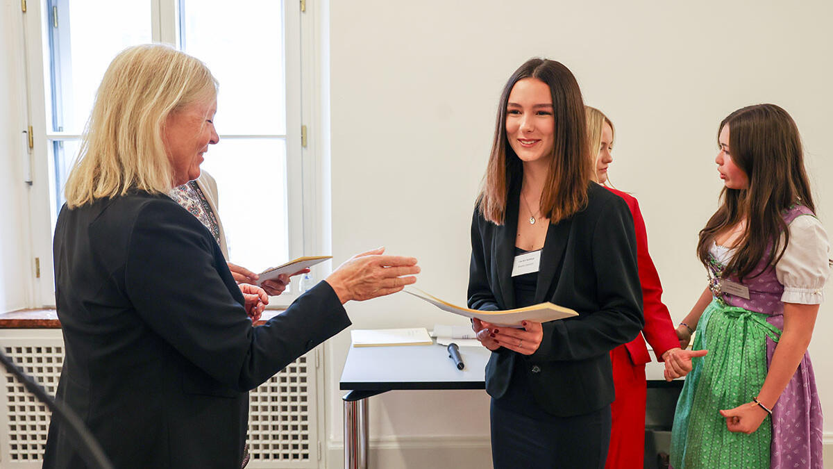 Lou Ann erhält ihre Urkunde bei der Stipendienvergabe "Botschafter Bayerns"