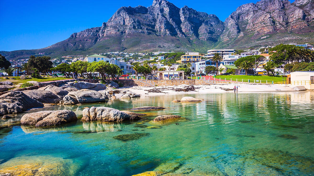 Strand in Südafrika mit kristallklarem Wasser und Bergkulisse