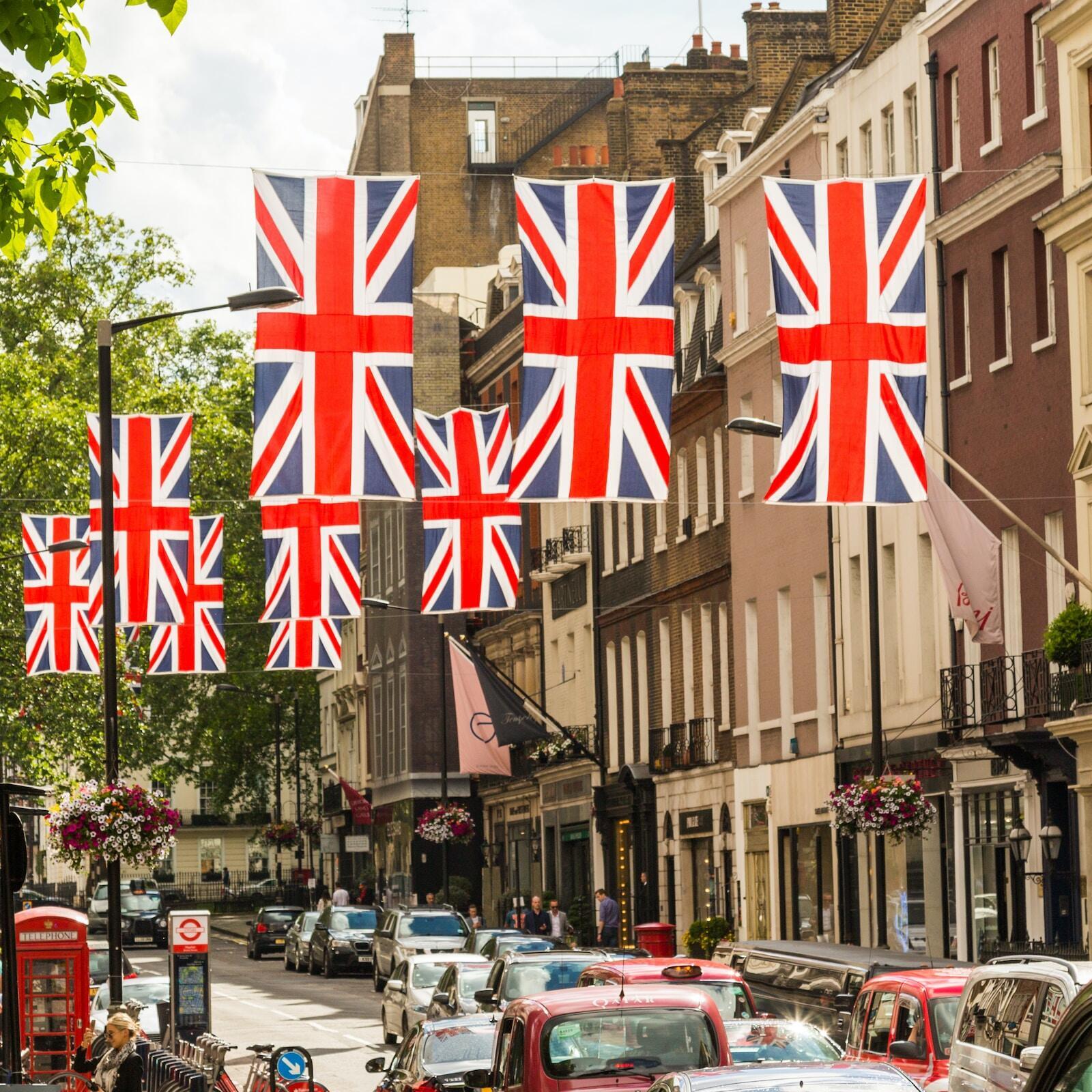Mehrere Reihen britischer Flaggen hängen über einer Straße.