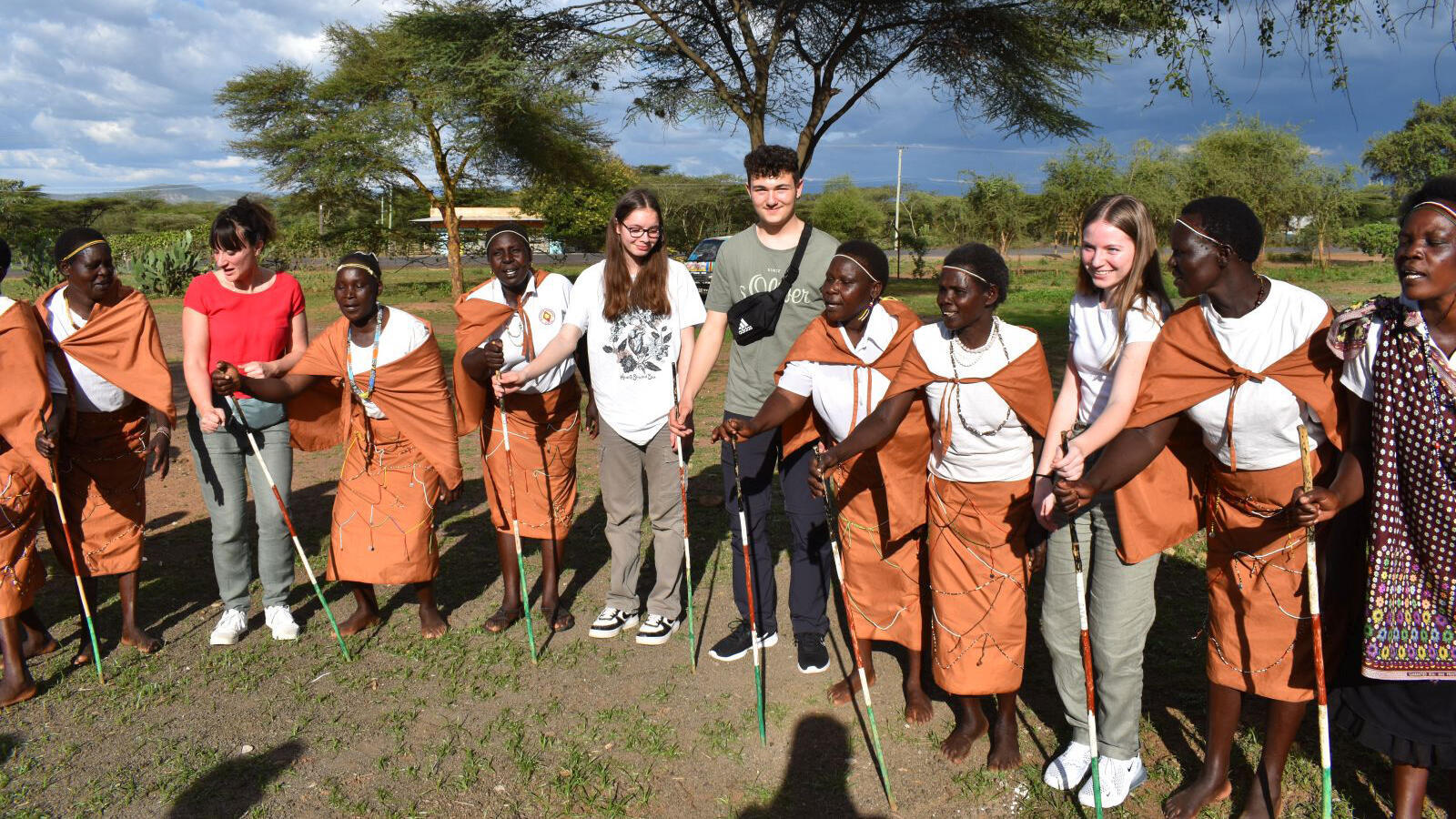 Schüler der Mittelschule Schwabmünchen stehen mit kenianischen Frauen in traditionellen Kostümen in einem Kreis