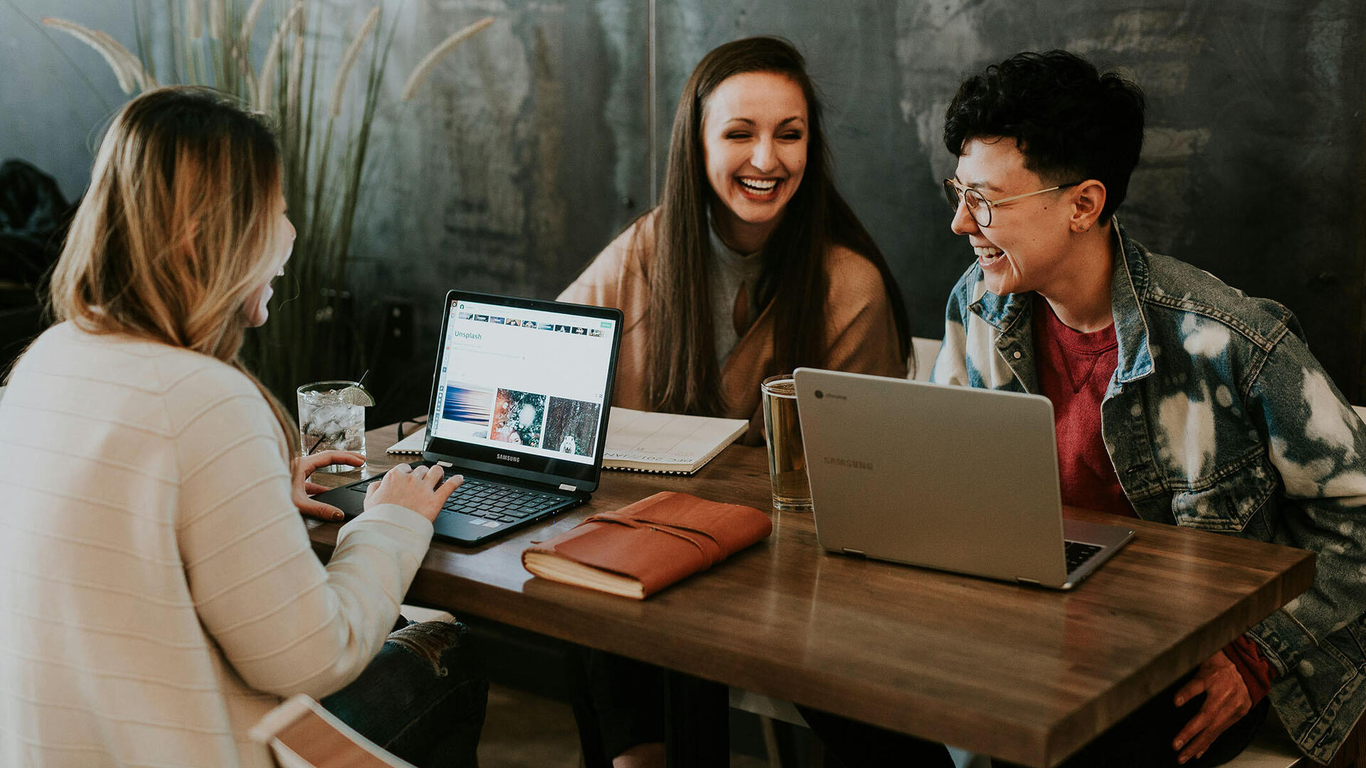 3 junge Frauen sitzen mit Laptops am Tisch