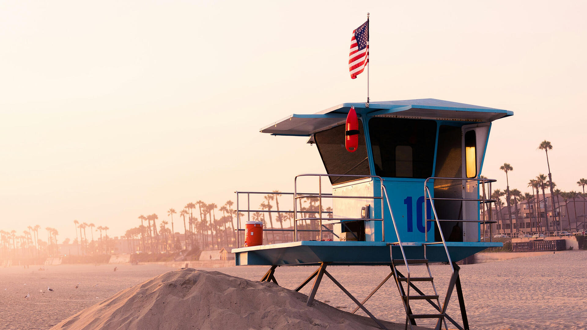 Amerikanische Flagge weht an einem Häuschen der Bademeister an einem Strand in Kalifornien