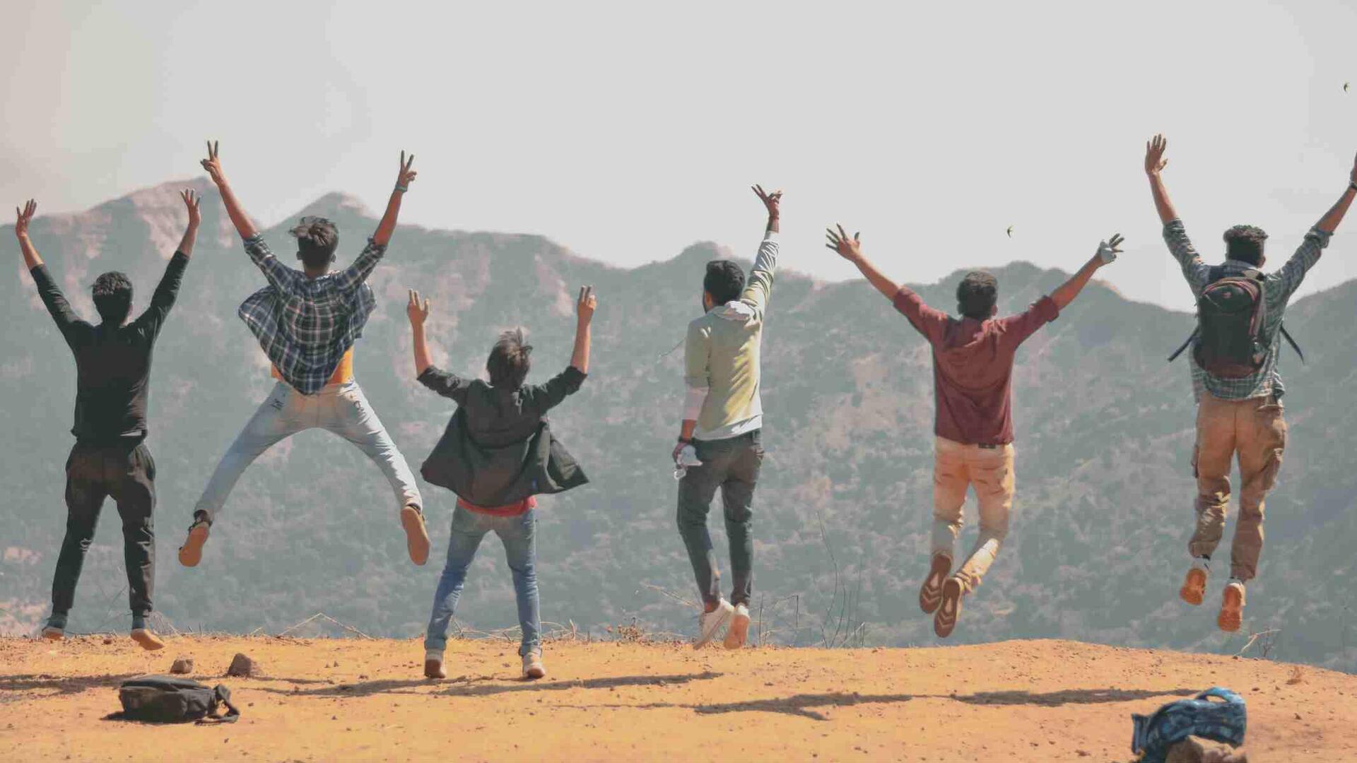 Gruppe von Menschen, die in die Höhe springen und die Arme in die Luft werfen