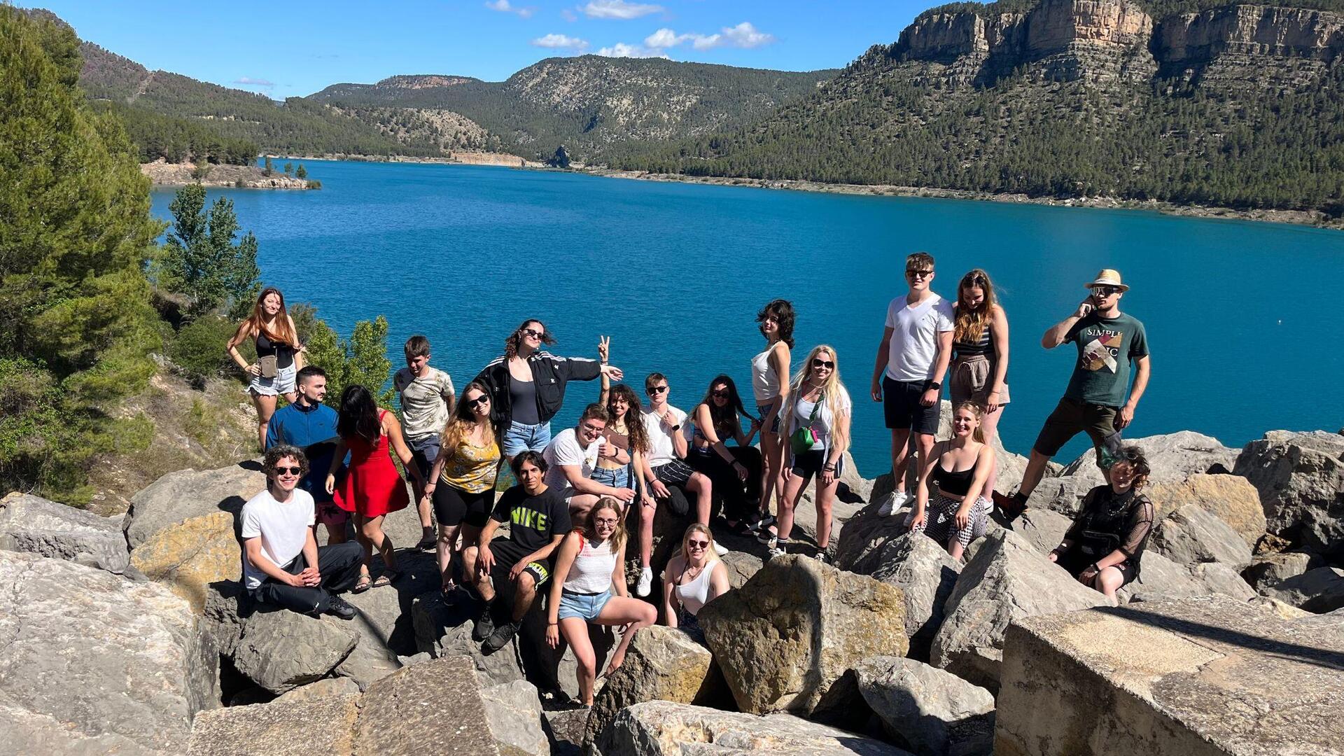 Jugendliche auf Felsen vor Bergsee
