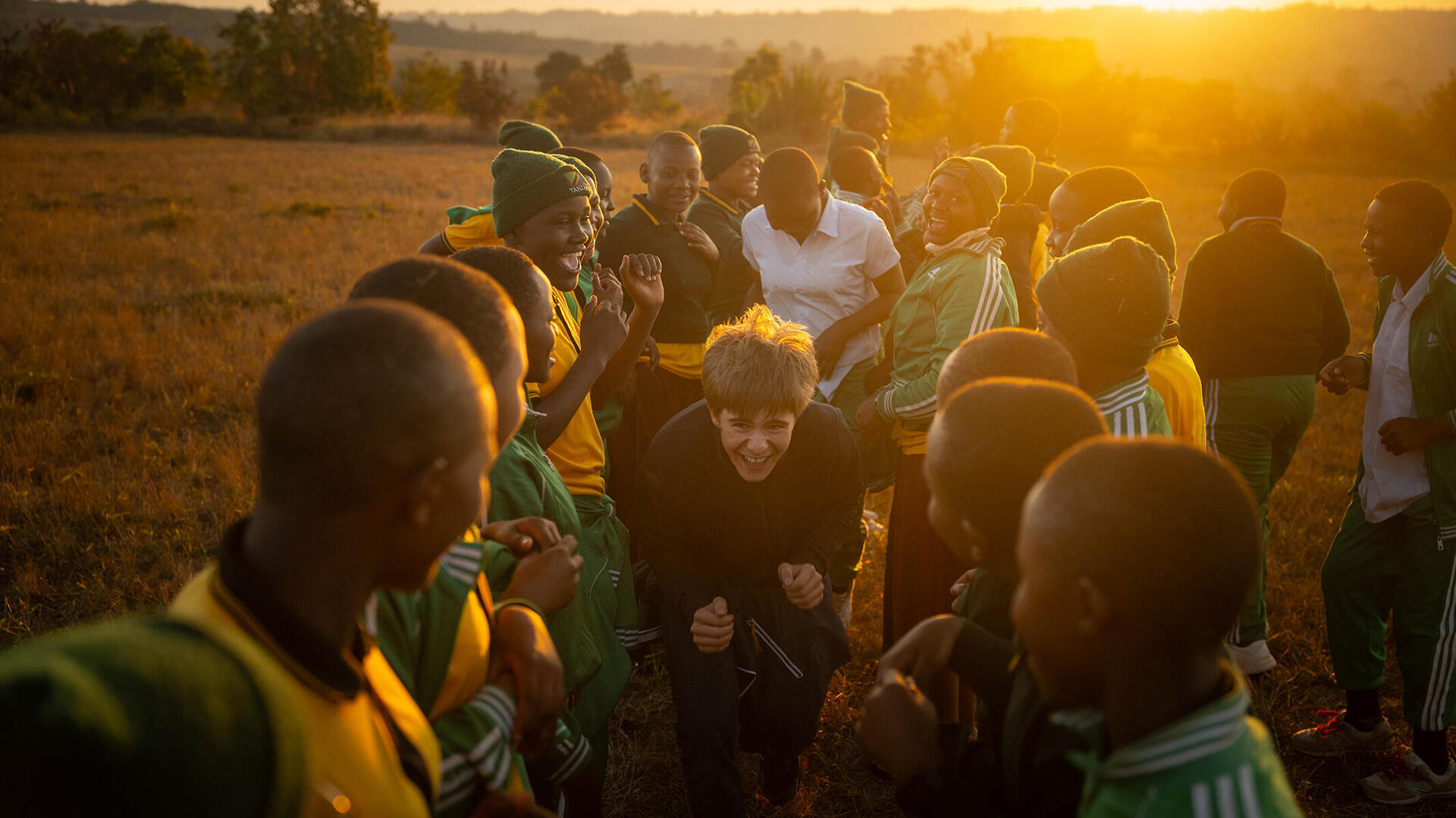 Schüler aus Gräfelfing beim Spiel mit tansanischen Schülerinnen und Schülern. Er rennt geduckt durch zwei Reihen.