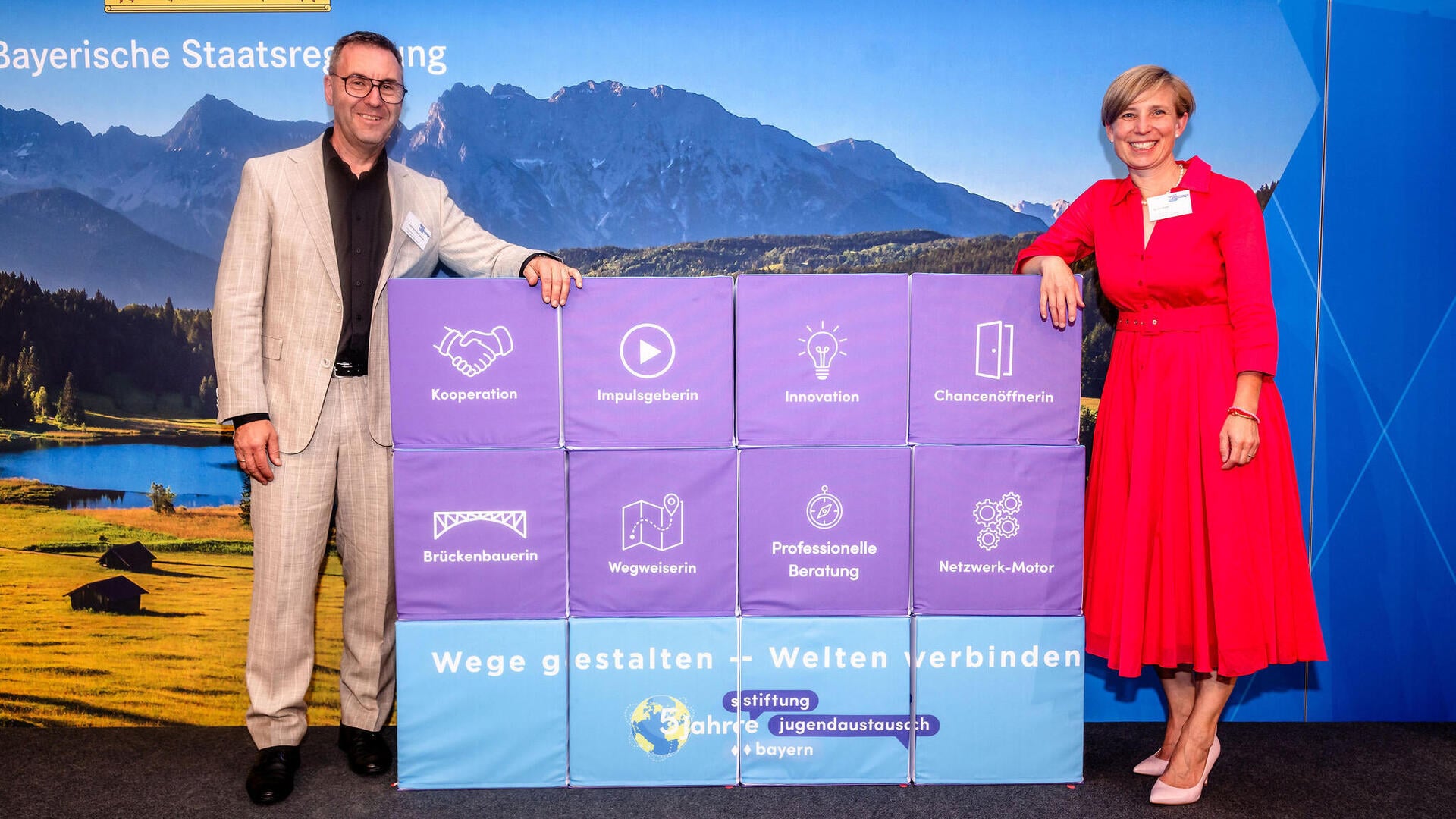 Geschäftführung Mirjam Eisele und Wolfgang Schwarzenberger beim Stiftungsjubiläum in München vor einer Würfelwand
