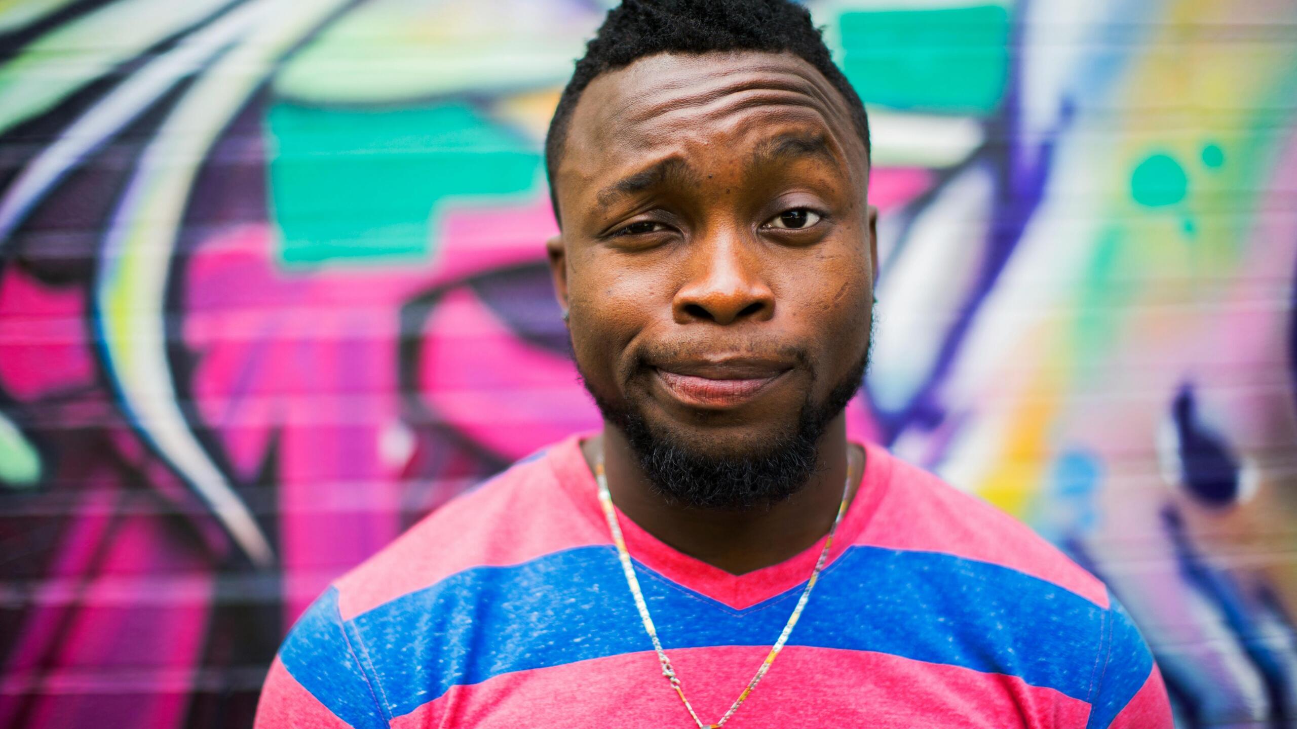 Schwarzhaariger Mann, der ein fragendes Gesicht macht