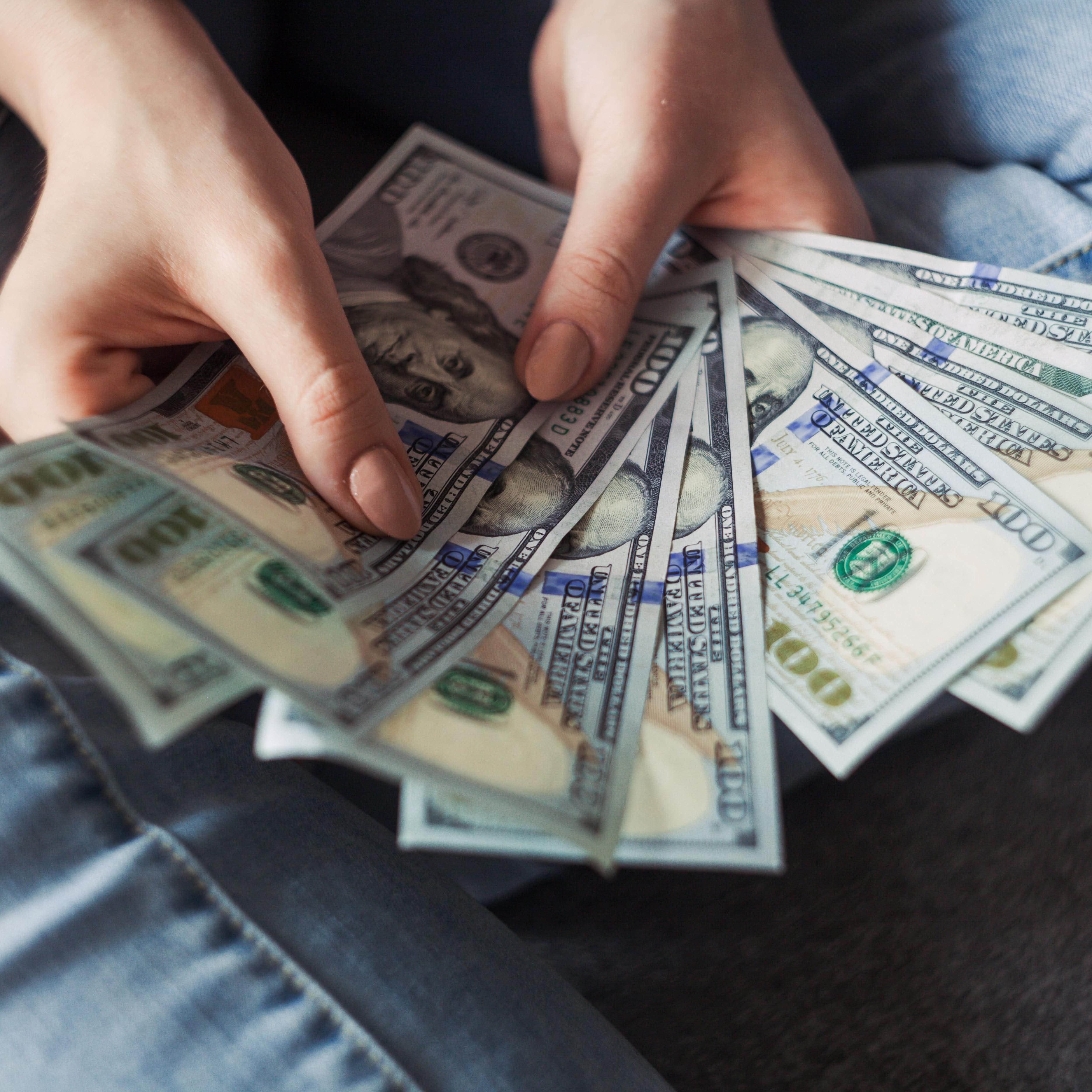 Eine Hand hält mehrere Dollarscheine