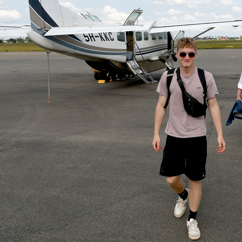 Andrija vor einem kleinen Passagierflugzeug auf dem Flughafen in Sansibar kurz vor dem Rückflug nach Dar es Salam