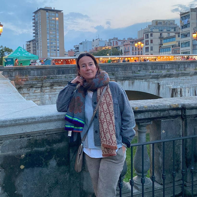 Manuela Winkler-Wolf steht vor einer Steinbrücke, im Hintergrund ist ein Markt zu sehen